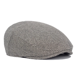 Detail of grey herringbone wool blend newsboy cap showing thick textured fabric weave