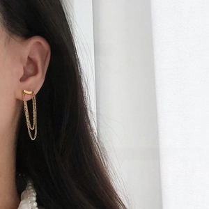Detail of 18K gold plated tassel chain earrings with a minimalist smile bar on the earlobe