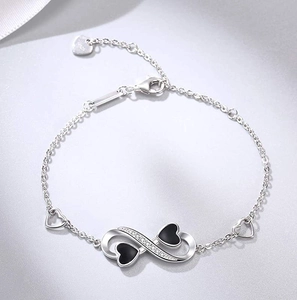 Detail view of the S925 sterling silver lobster clasp and infinity symbol charm with diamonds