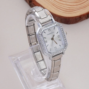 Detailed close-up of a silver square quartz watch with rhinestones and stainless steel band