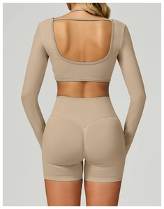 Detail of back cutout and slim fit design on beige long sleeve yoga top and shorts set