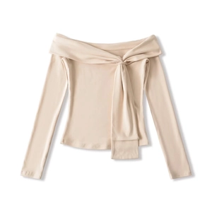Close-up of beige off-shoulder top featuring an elegant ribbon tie knot design