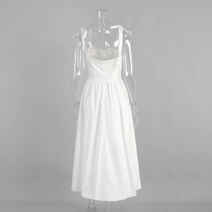 Vue arrière d'une robe midi en coton blanc avec bretelles nouées et dos nu élégant