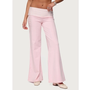 Detail of light pink flare pants featuring a striped fold-over waistband design