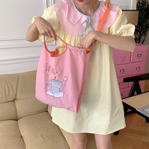 Close-up of cute elephant embroidery and vibrant orange rope straps on pink tote bag