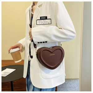 Vue détaillée du sac bandoulière coeur marron foncé avec inscription dorée FASHION & BAG