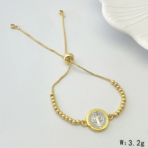 Detailed macro view of Saint Benedict heart charm on adjustable gold beaded bracelet