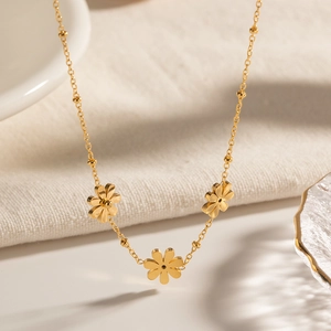 Collier ras du cou doré avec trois pendentifs marguerites et une chaîne perlée élégante