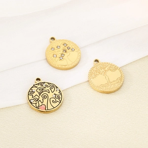 Detailed close-up of three gold stainless steel Tree of Life pendants with crystals and engraving