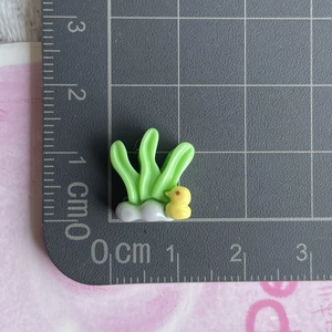Miniature seagrass and duck resin charms on a grid mat showing 2cm scale detail