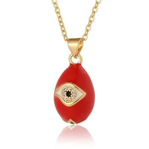 Macro shot of red water-drop Evil Eye pendant with zircon inlay and gold chain