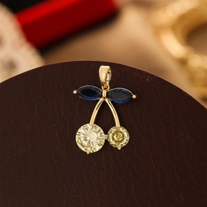 Detailed view of cherry pendant with blue leaf stones and yellow faceted gems