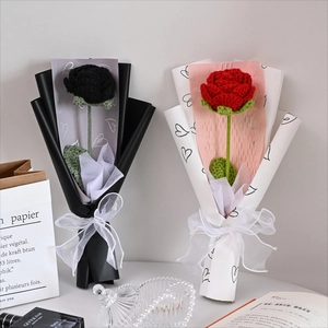 Detail of handcrafted crochet roses in black and red with elegant white chiffon bow