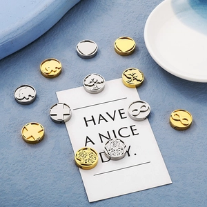 Detailed macro view of 15mm stainless steel charms with golden and silver assorted patterns