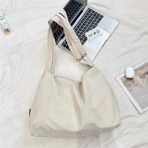 Detail view of large cream canvas tote fabric texture and adjustable wide shoulder strap
