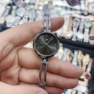 Gros plan d'une montre bracelet en métal argenté avec cadran gris foncé et logo Jw