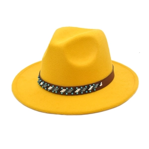 Détail chapeau fedora en laine jaune avec ruban en cuir perlé et bord large élégant