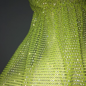 Close-up of neon green mesh fabric featuring sparkling rhinestones for party headwear