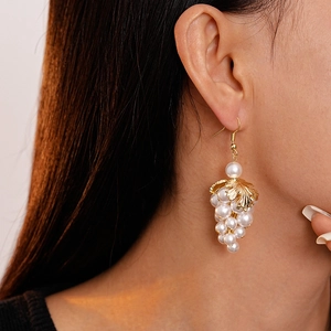 Baroque grape pearl tassel earrings with gold leaf accents on a female model