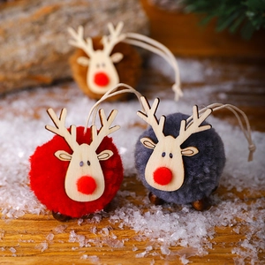 Detail of wool felt reindeer ornaments with wood texture and red noses on a tree