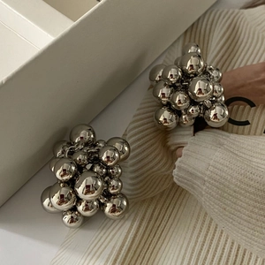 Macro detail of silver grape-shaped cluster stud earrings with metallic spheres