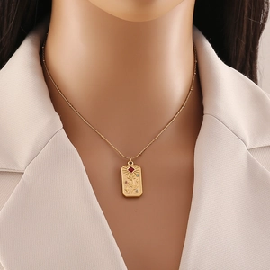 Vintage gold rose tarot pendant necklace with red gem on professional fashion model