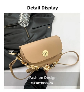 Close-up of saddle bag lock with silk scarf chain handle and neutral beige texture