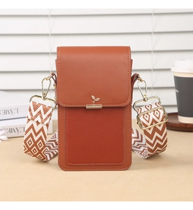 Detail of caramel mini crossbody bag with wide geometric strap and golden hardware