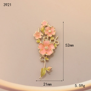 Detail view of 52mm floral alloy pendant with pink enamel petals and golden leaf finish