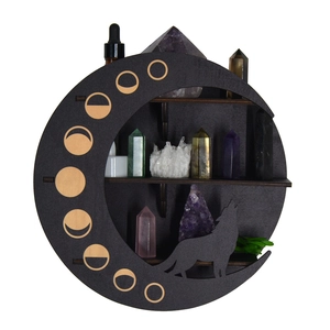 Detail of wooden crescent moon crystal shelf with wolf silhouette and gold phase prints