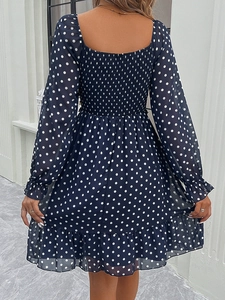 Detailed back view of navy polka dot chiffon dress showing smocked elastic waist and ruffles
