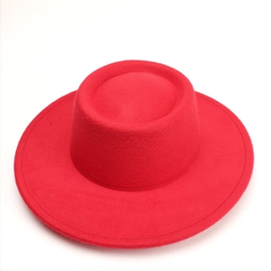 Top view of bright red wool felt boater hat with a wide flat brim and structured crown
