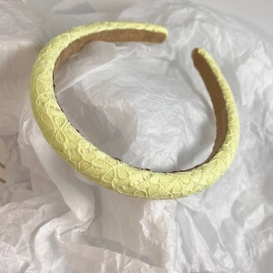 Detailed macro view of the yellow floral lace fabric and sponge headband padding