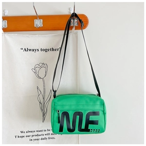 Détail de la sacoche en nylon vert pour enfant avec imprimé lettre ME et fermeture
