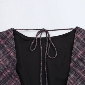 Detail view of purple plaid dress featuring a neck tie-knot and black contrast lining