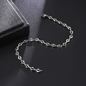 Silver coffee bean link bracelet with lobster clasp on a textured black surface