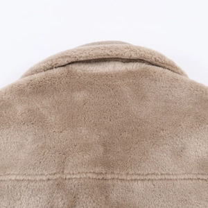 Detailed macro view of soft camel faux fur collar and shoulder texture on warm winter coat