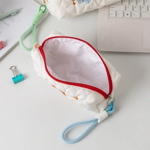 Macro view of quilted heart pattern pencil case with red zipper and braided strap