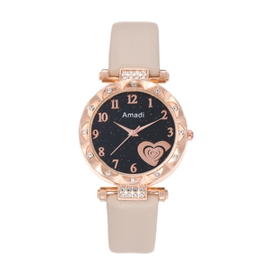 Detail of rose gold starry dial watch with heart pattern and beige leather strap