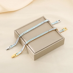 Macro detail of silver and gold tennis bracelets with rainbow zircons on a leather box
