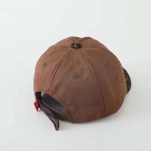 Detail view of the brown suede baseball cap back with leopard print strap and red smile tag