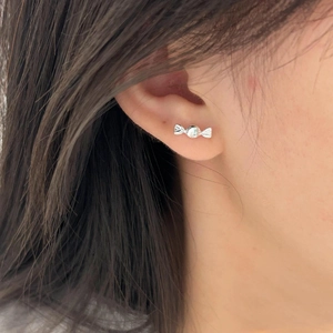 Close-up of a 925 sterling silver candy-shaped stud earring worn on a model's ear