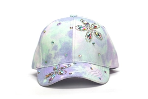 Dettaglio del cappellino da baseball tie-dye per bambini con decorazioni floreali in strass