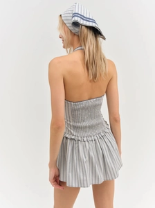Rear view of striped halter dress featuring an open back and elastic shirred details