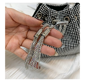 Close-up of black rhinestone bucket bag with sparkling silver metal chain tassels