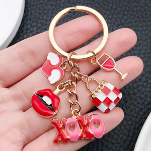 Golden keychain with red enamel charms like winged heart, lips and XOXO pendant