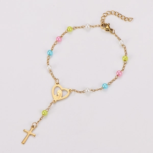 Détail d'un bracelet en perles dorées avec icône de cœur et pendentif crucifix