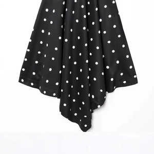 Retro black and white polka dot sleeveless top with elegant fabric drape and pleats