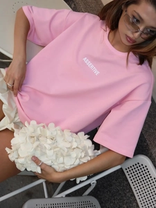 Dettaglio della maglietta in cotone rosa con stampa ASSERTIVE bianca in esterno