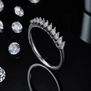 Macro detail of marquise cut moissanite ring with sparkling stones on black background